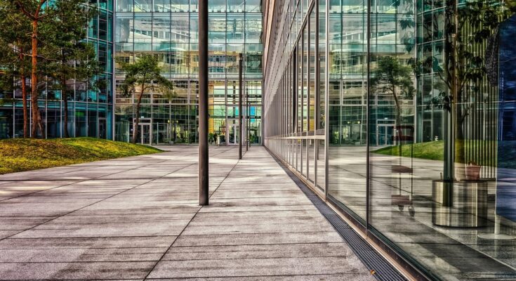 Minimalist illustration with a gradient background and a sleek glass storefront icon, symbolizing versatile commercial glass company services.